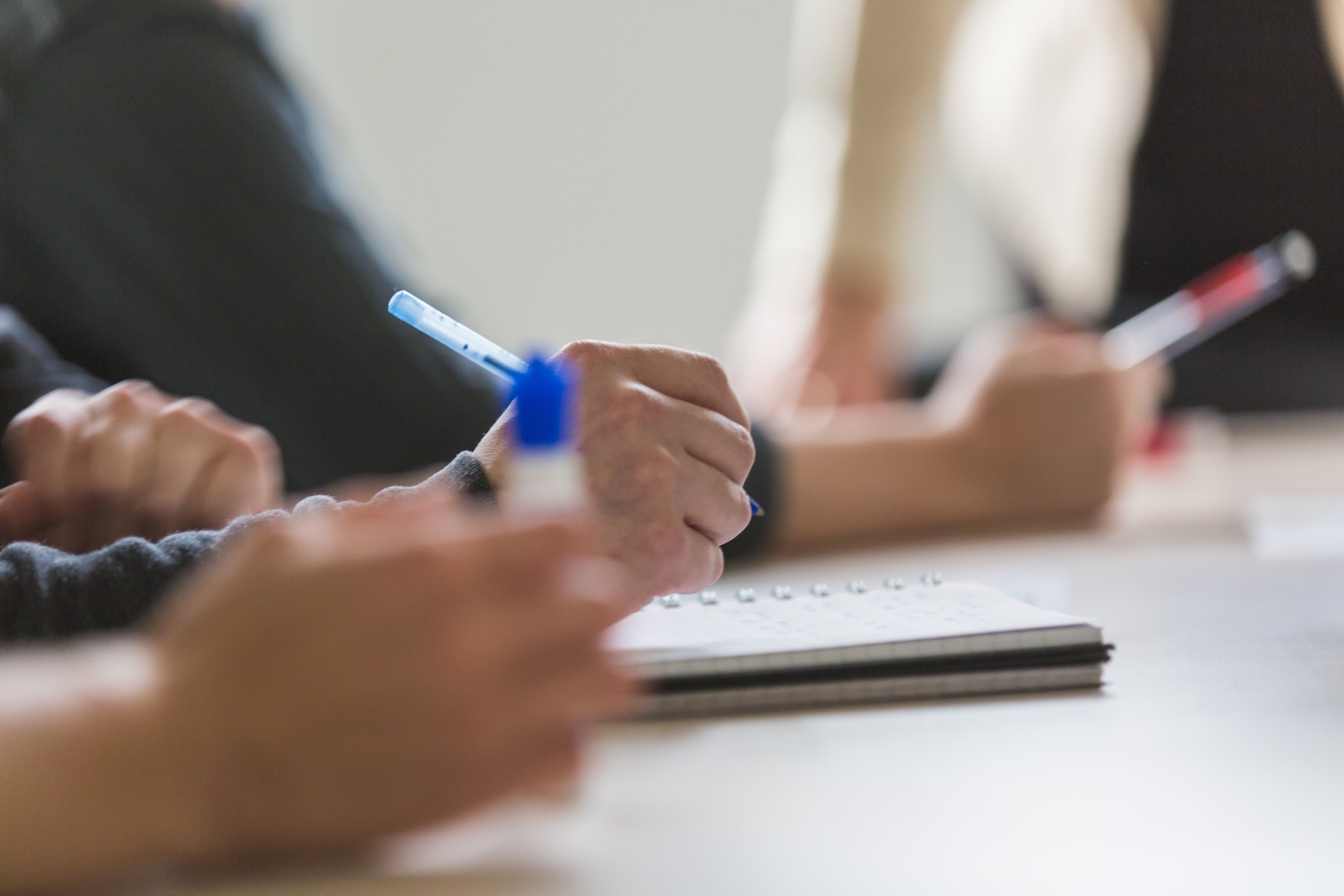 People taking notes in a meeting or training course